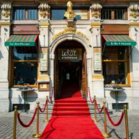Rode loper met rode fluweelkoorden en gouden palen aan de ingang van brasserie Le Roy d'Espagne op de Grote Markt van Brussel. (afbeelding deels bewerkt met AI)