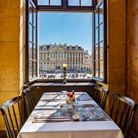 Gedekte tafel naast een open raam met uitzicht op de Grote Markt van Brussel