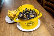Una cazuela amarilla con moules marinières, una de las especialidades de Le Roy d'Espagne