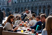 Vista de la soleada terraza de Le Roy d'Espagne, con el Ayuntamiento al fondo