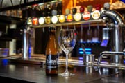 Una botella de cerveza 'La Roy d'Espagne' sobre la barra junto a su vaso